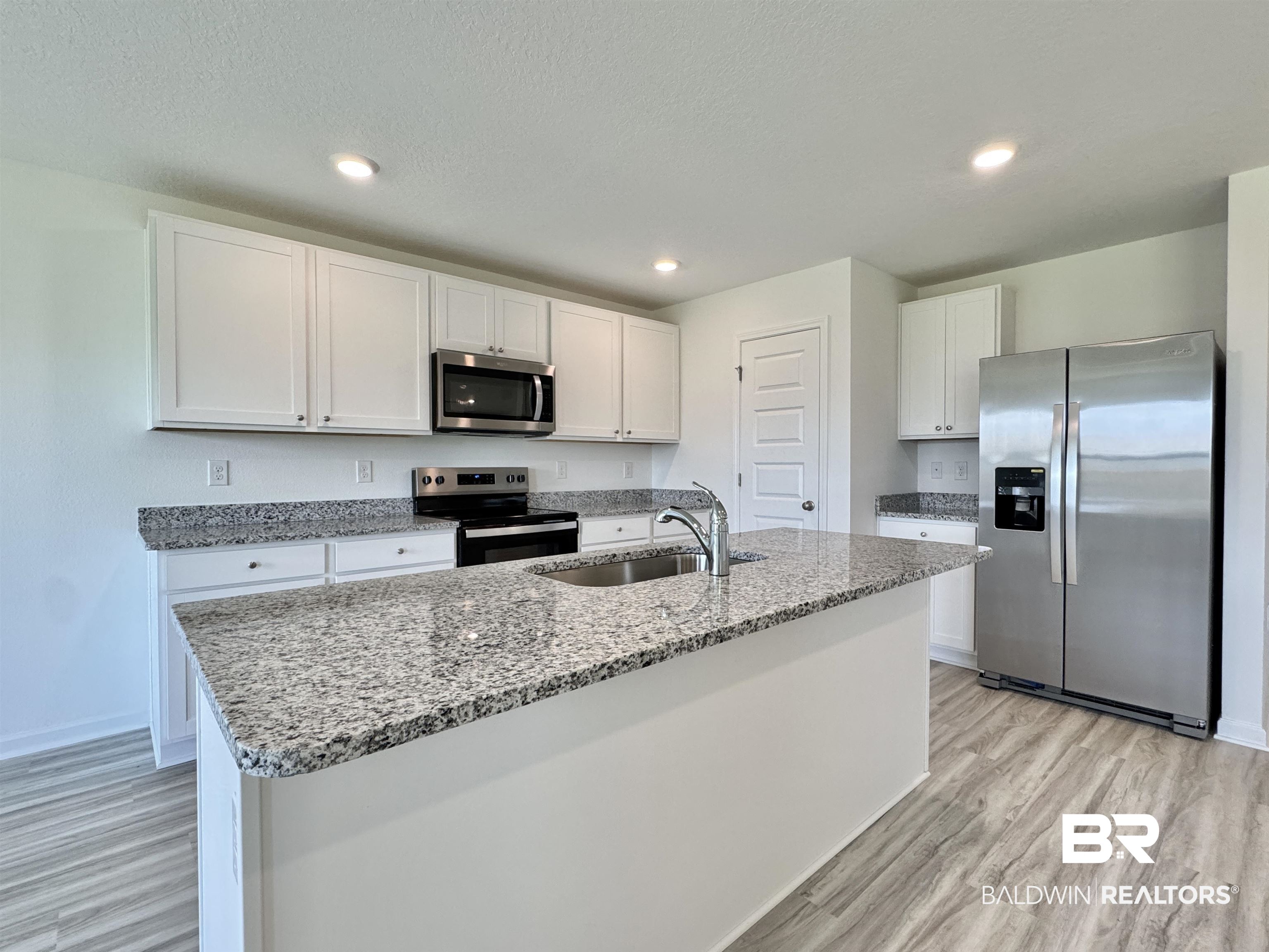 22072 Aleutian Avenue Foley, AL 36535 - Photo 32 of 47 Kitchen with appliances with stainless steel finishes, light wood-style flooring, white cabinets, light stone countertops, and recessed lighting