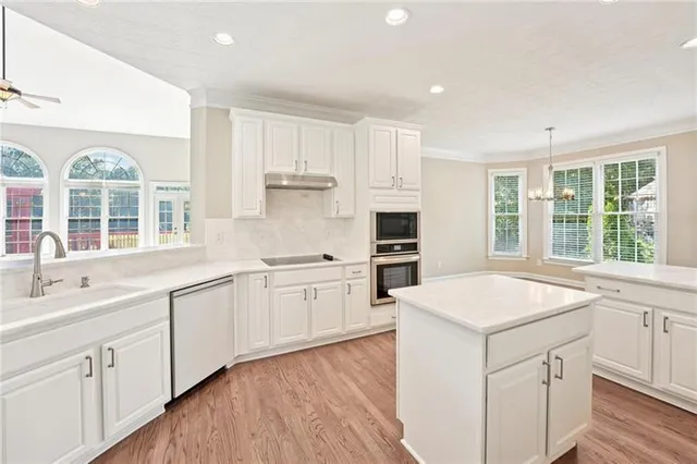 a kitchen with granite countertop white cabinets and white appliances