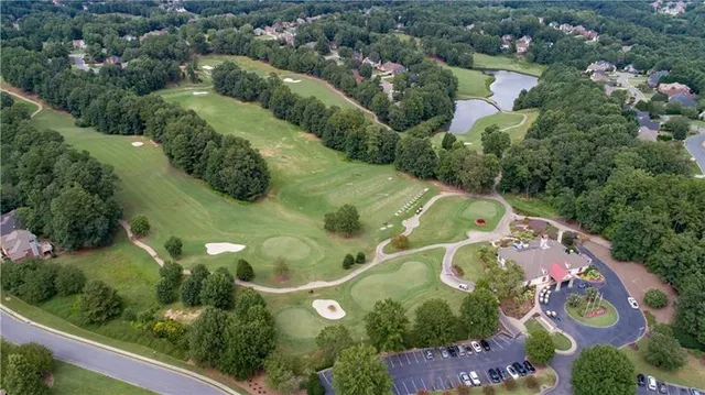 a view of a hallway with wooden floor and a bathroom