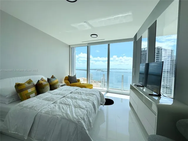 a bedroom with furniture and a large window