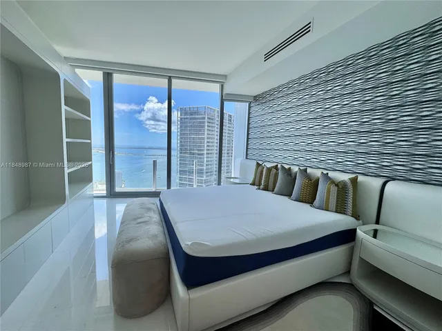 a bedroom with a large bed and a large window