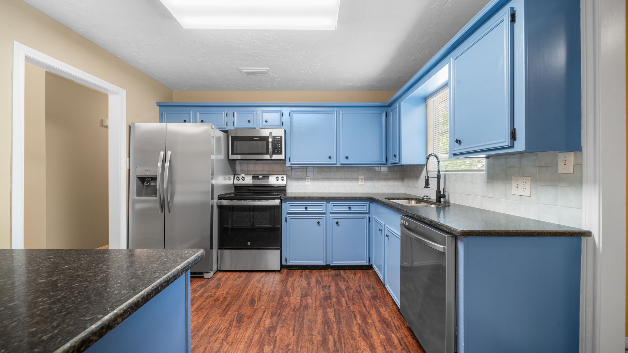 417 Shawnee Conroe, TX 77316 - Photo 5 of 18 Updated kitchen featuring stainless steel appliances, ample cabinetry, and generous counter space.