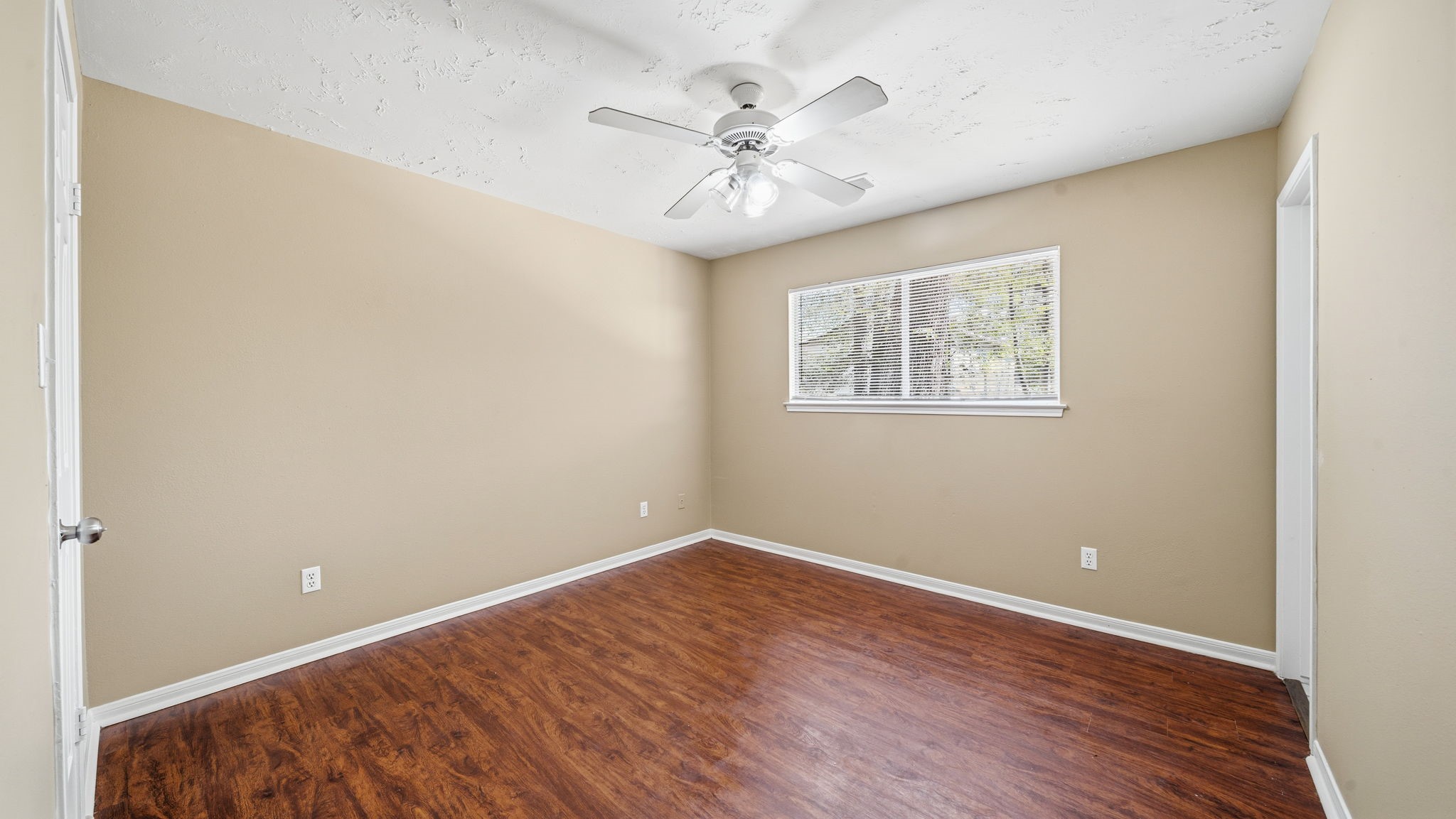 417 Shawnee Conroe, TX 77316 - Photo 10 of 18 Spacious primary bedroom with wood-style flooring and natural light.