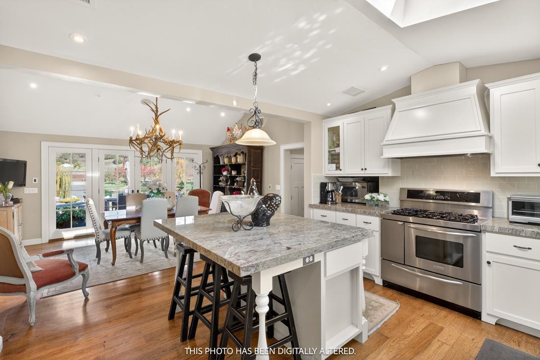 3970 Leavesley Road Gilroy, CA 95020 - Photo 40 of 52 a open kitchen with stainless steel appliances granite countertop a stove top oven a sink dishwasher a dining table and chairs with wooden floor