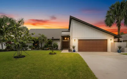a view of a house with backyard and trees