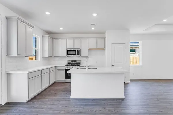 a kitchen with stainless steel appliances sink refrigerator and microwave
