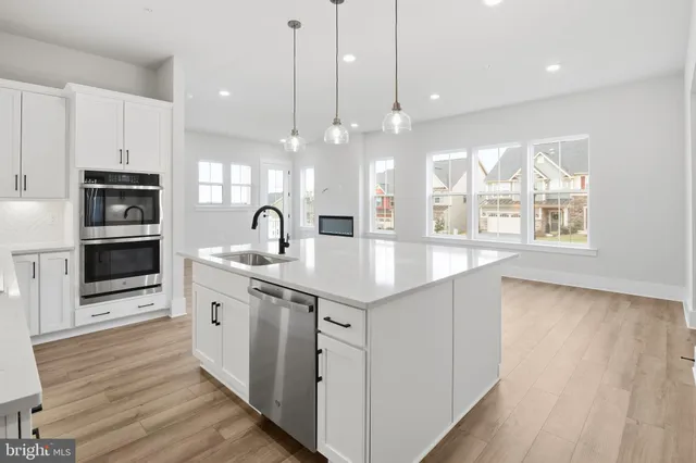 a kitchen with kitchen island granite countertop a sink appliances and cabinets