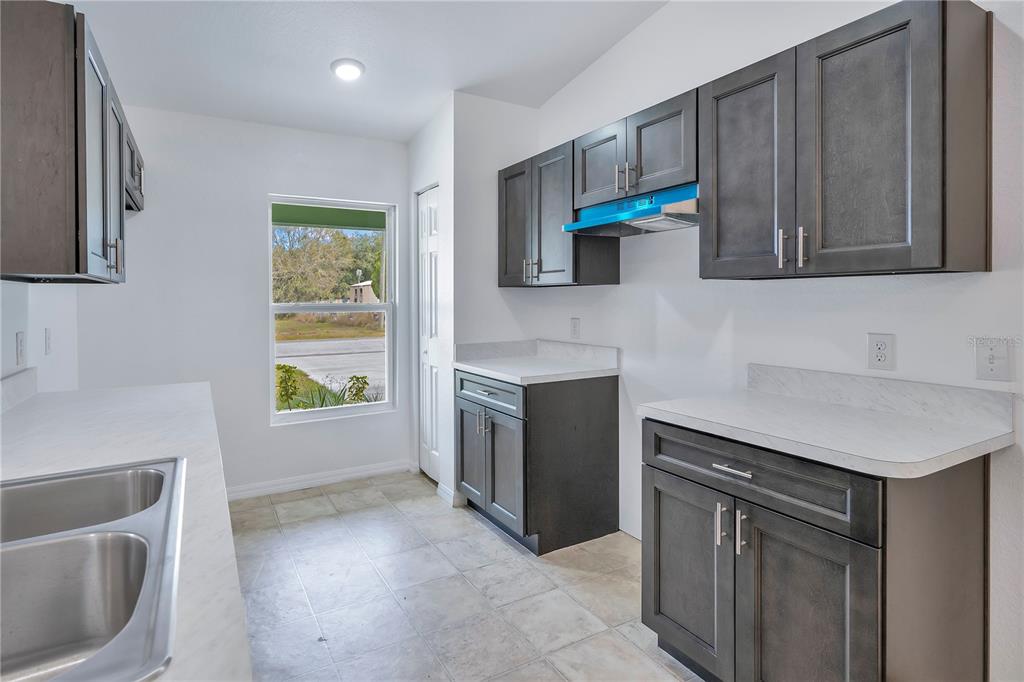 833 3rd Avenue Dundee, FL 33838 - Photo 11 of 37 a kitchen with a sink stove and cabinets