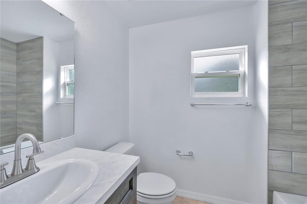 833 3rd Avenue Dundee, FL 33838 - Photo 17 of 37 a bathroom with a sink a toilet and mirror
