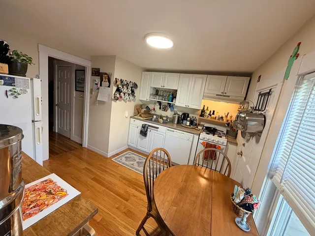 a view of a kitchen with furniture and wooden floor