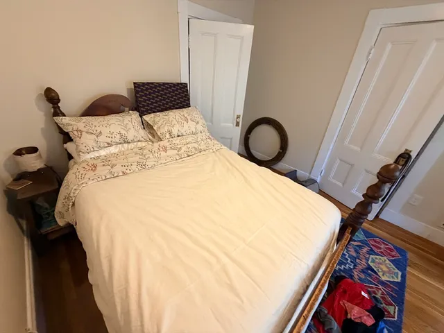 a bed sitting in a bedroom next to a window