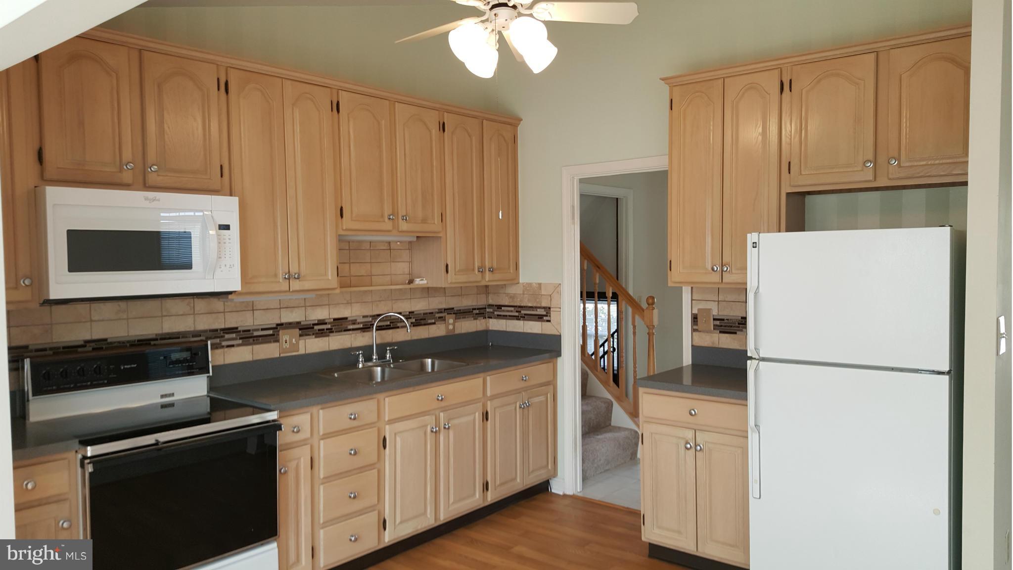 9003 Transoms Road Baltimore, MD 21236 - Photo 2 of 29 a kitchen with a refrigerator sink and cabinets