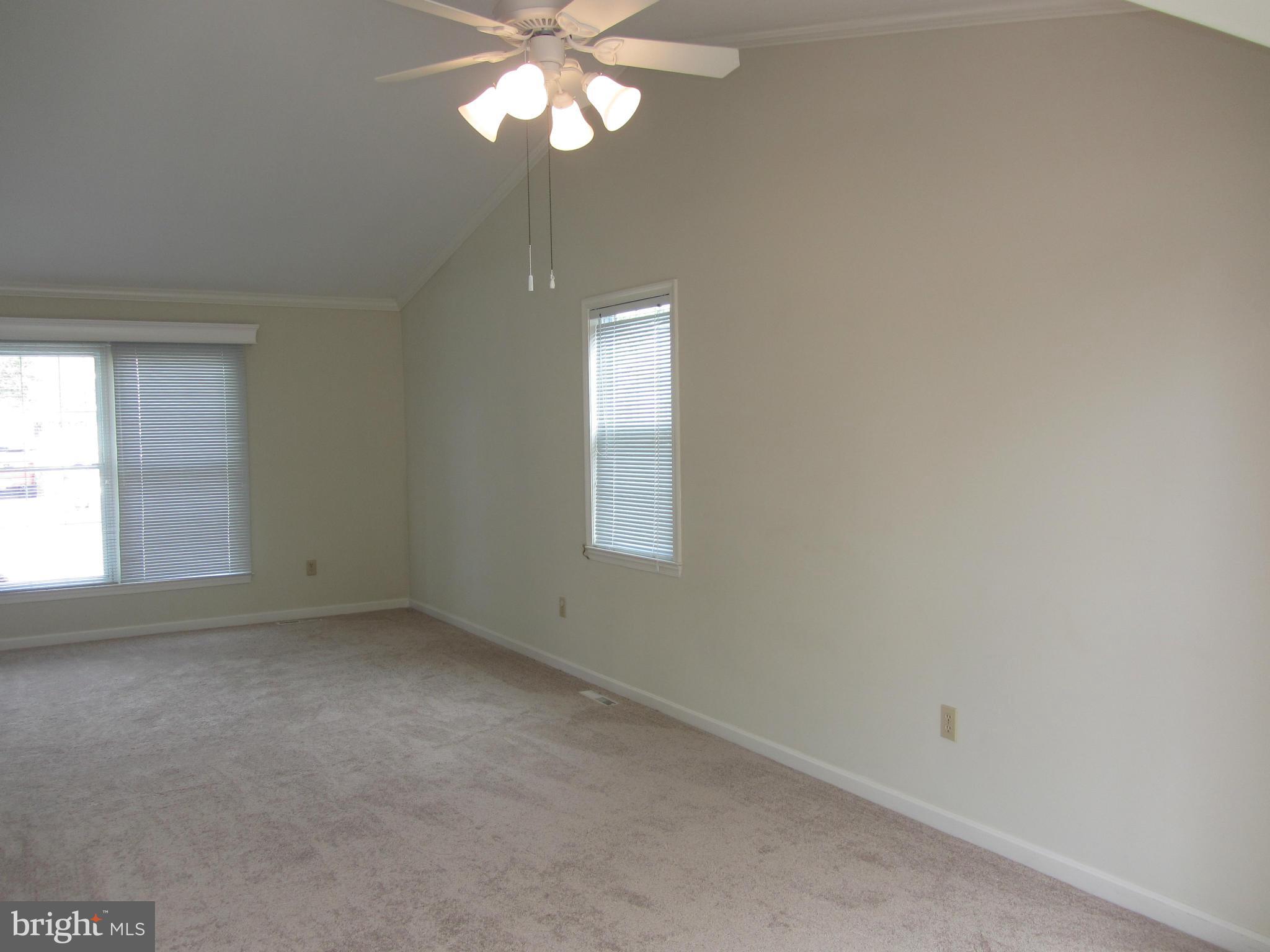 9003 Transoms Road Baltimore, MD 21236 - Photo 11 of 29 an empty room with a chandelier fan and windows