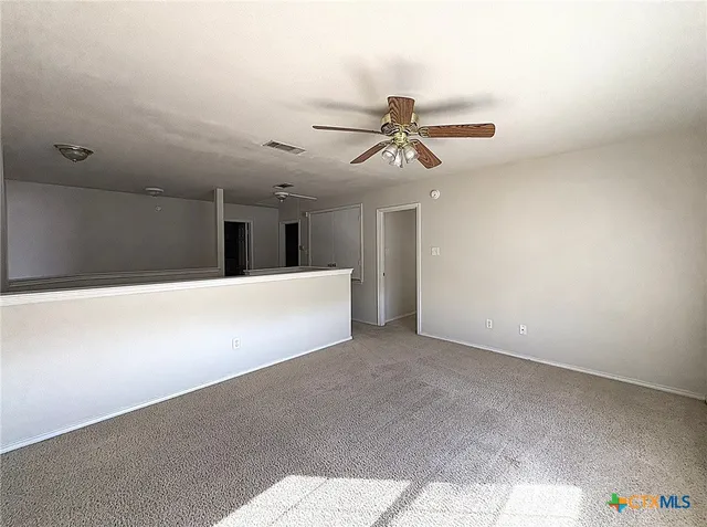 a view of a livingroom with a ceiling fan and wooden floor