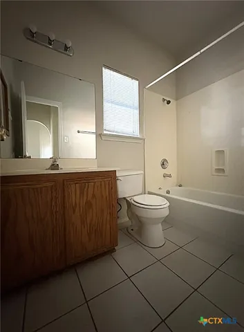 a bathroom with a granite countertop sink a toilet and a mirror