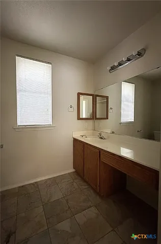 a spacious bathroom with a vanity a sink a mirror and a bathtub