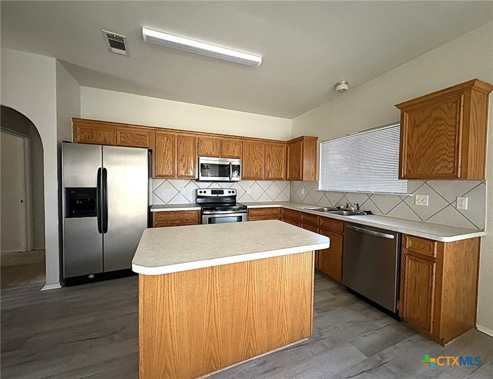 2313 Modoc Drive Harker Heights, TX 76548 - Photo 5 of 34 a kitchen with stainless steel appliances granite countertop a sink a stove a refrigerator with grey cabinets and wooden floor