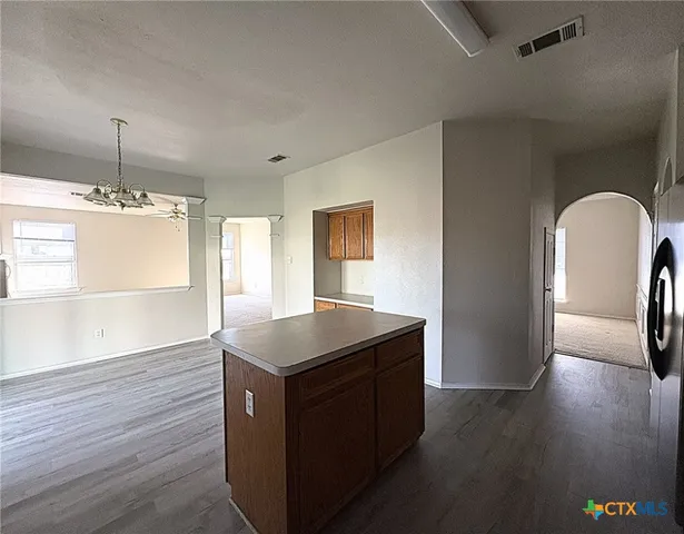 a kitchen with stainless steel appliances granite countertop a sink a stove and island with wooden floor