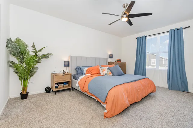 a bedroom with bed and a potted plant