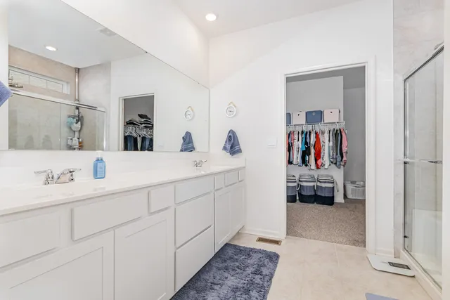 a en suite bathroom with a double vanity sink and a mirror