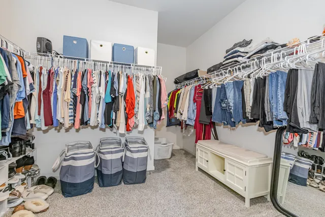 a view of walk in closet with clothes