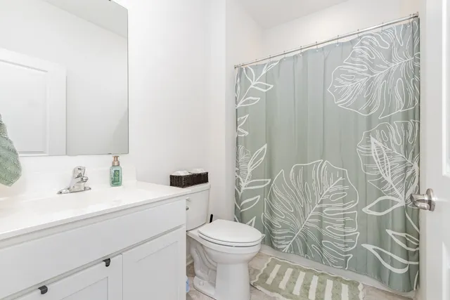 a bathroom with a sink a toilet and shower curtain
