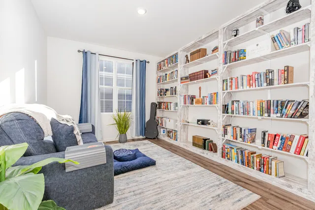 a living room with furniture and a book shelf
