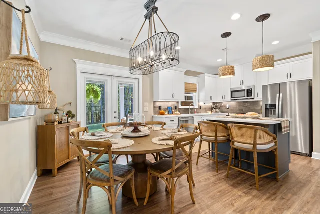 a view of a dining room and livingroom with furniture wooden floor a chandelier