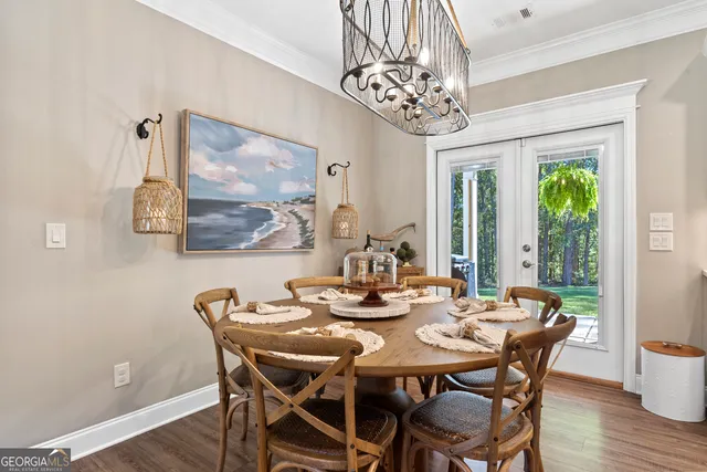 a dining room with furniture a chandelier and wooden floor