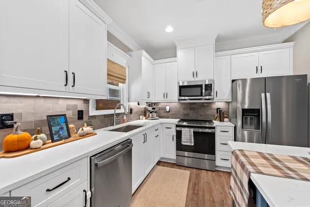 a kitchen with stainless steel appliances granite countertop a refrigerator stove microwave and sink