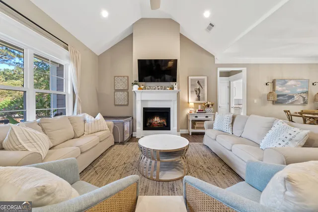 a living room with couches a fireplace and a flat screen tv