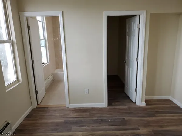 an empty room with wooden floor and entrance