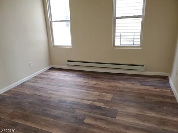 a view of a room with wooden floor and a window