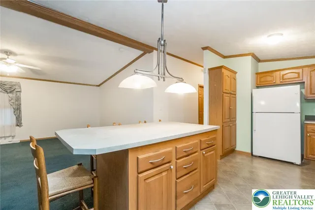 a kitchen with a table chairs and refrigerator