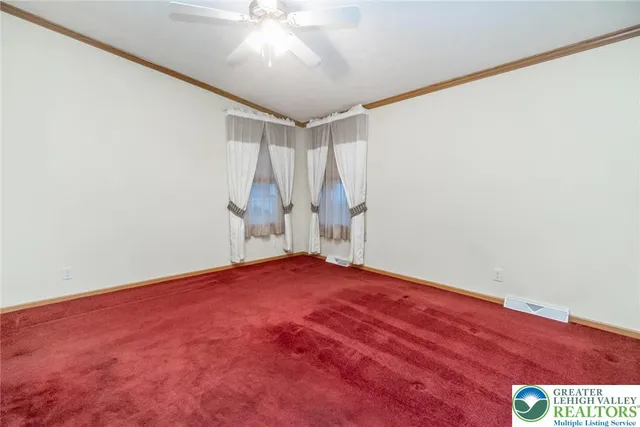 an empty room with a white ceiling fan and wooden floor
