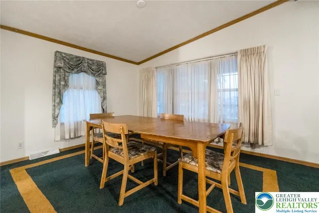 a dining room with a wooden table and chairs