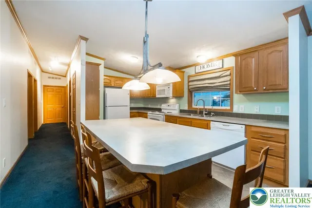 a kitchen with a table chairs sink and wooden floor