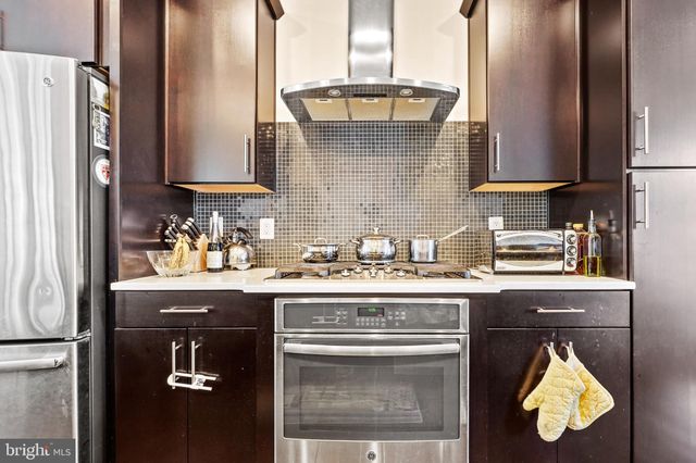 a kitchen with stainless steel appliances granite countertop a sink and a stove