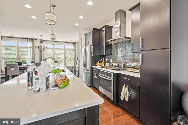 a kitchen with stainless steel appliances granite countertop a sink a stove and a refrigerator