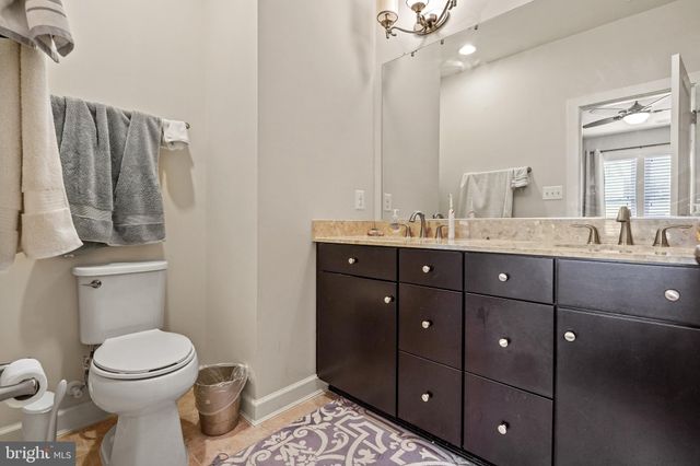 a bathroom with a double vanity sink toilet and mirror
