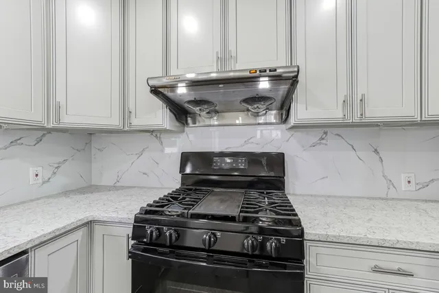 a stove top oven sitting inside of a kitchen