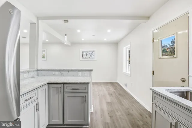 a kitchen with a sink cabinets and wooden floor