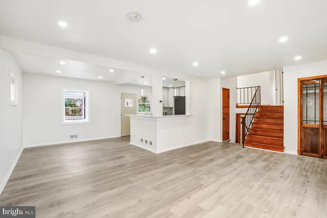 a view of a livingroom with wooden floor and a ceiling fan