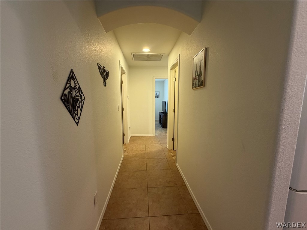 2416 North Ridge Avenue Bullhead City, AZ 86429 - Photo 15 of 33 Hallway with light tile patterned floors, arched walkways, and a textured wall