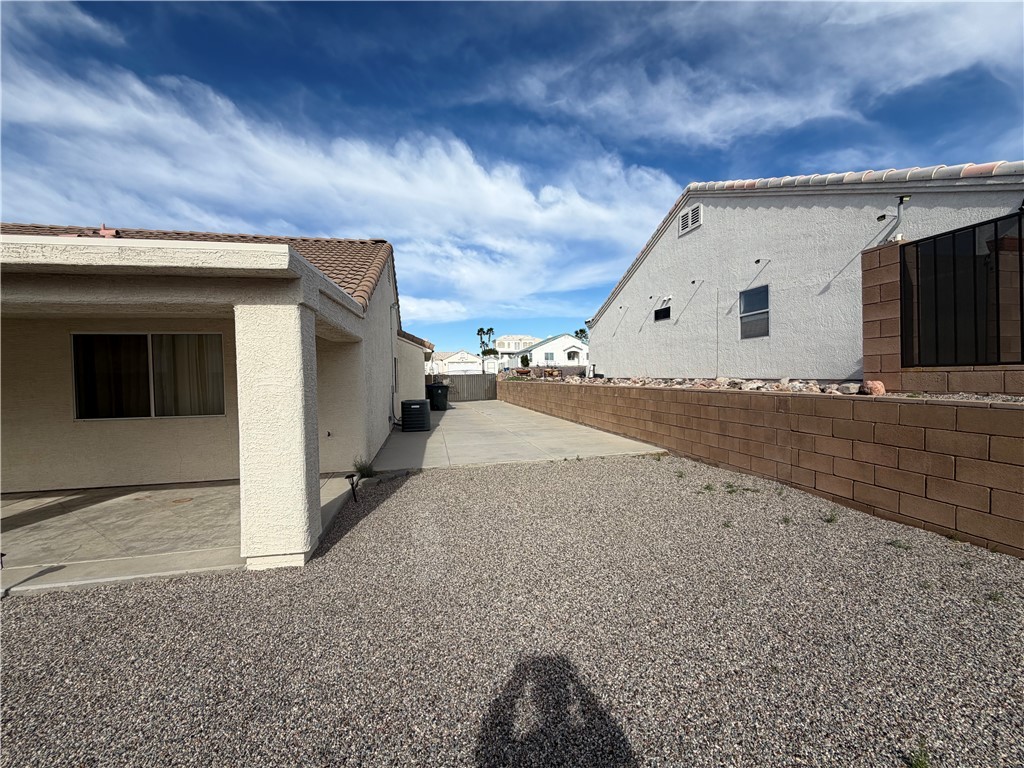 2416 North Ridge Avenue Bullhead City, AZ 86429 - Photo 32 of 33 View of side of property with stucco siding, a fenced backyard, a patio area, and a tile roof