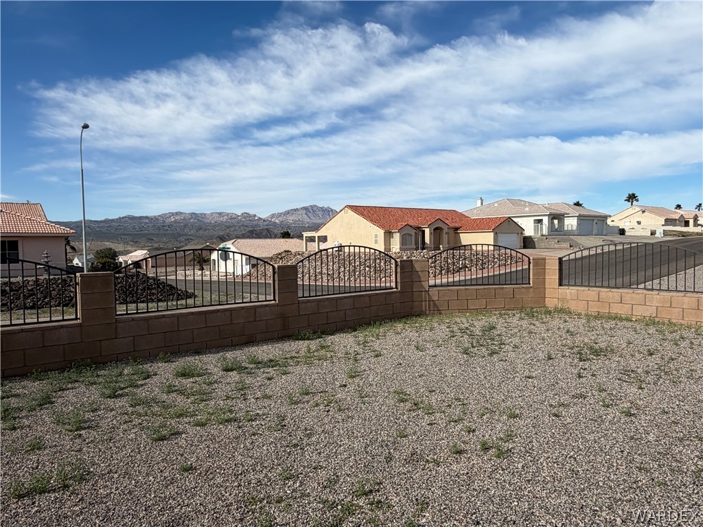 2416 North Ridge Avenue Bullhead City, AZ 86429 - Photo 7 of 33 View of yard with a residential view, a gate, and a mountain view