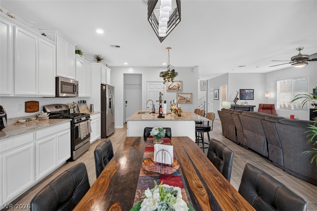 1824 Redland Ridge Street Henderson, NV 89002 - Photo 15 of 69 An open-concept living area flows seamlessly, connecting a modern kitchen, spacious dining, and comfortable lounge.