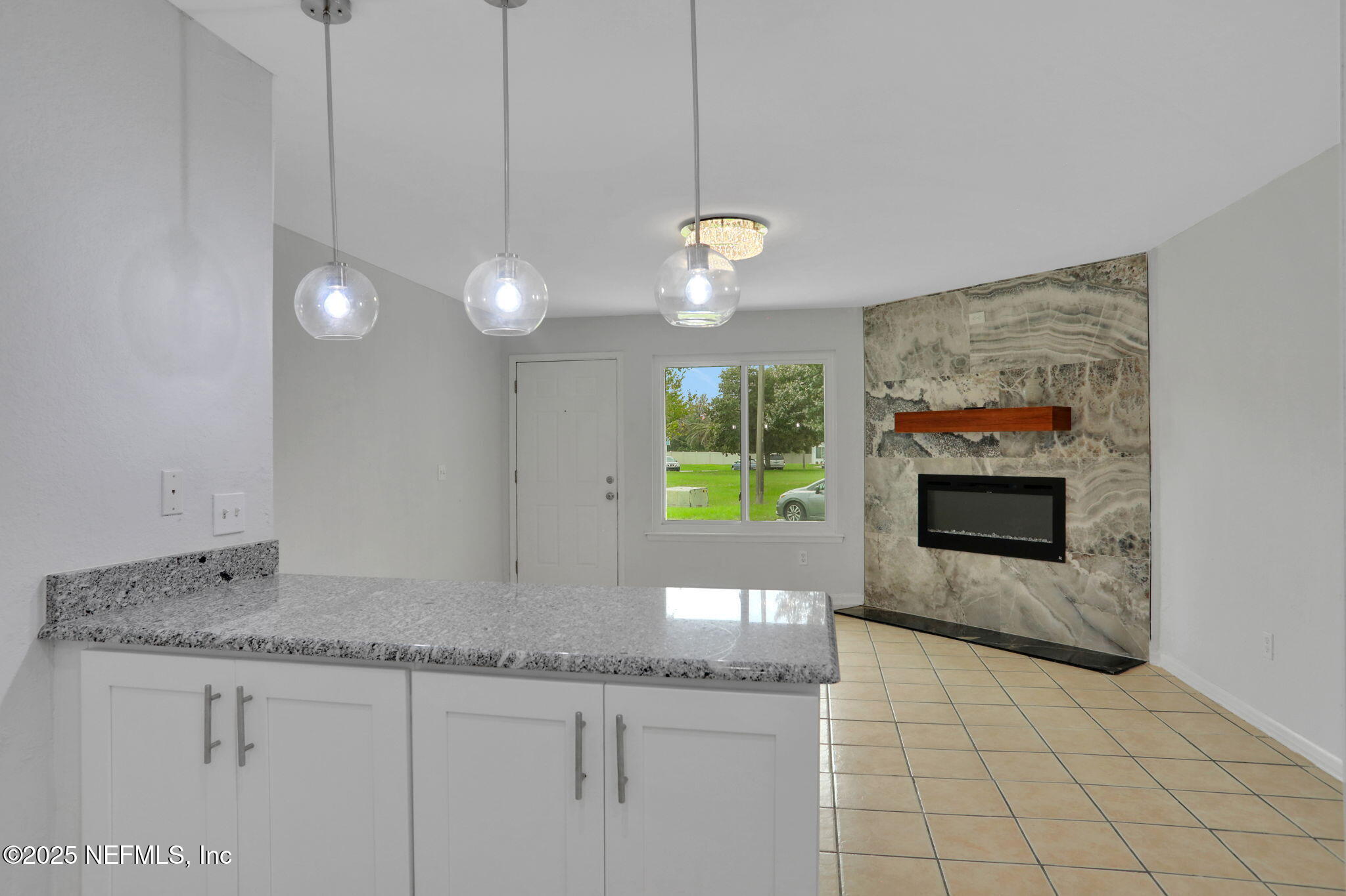 791 Assisi Lane, Unit 1704 Jacksonville, FL 32233 - Photo 5 of 16 a kitchen with granite countertop a stove a sink and a wooden floors