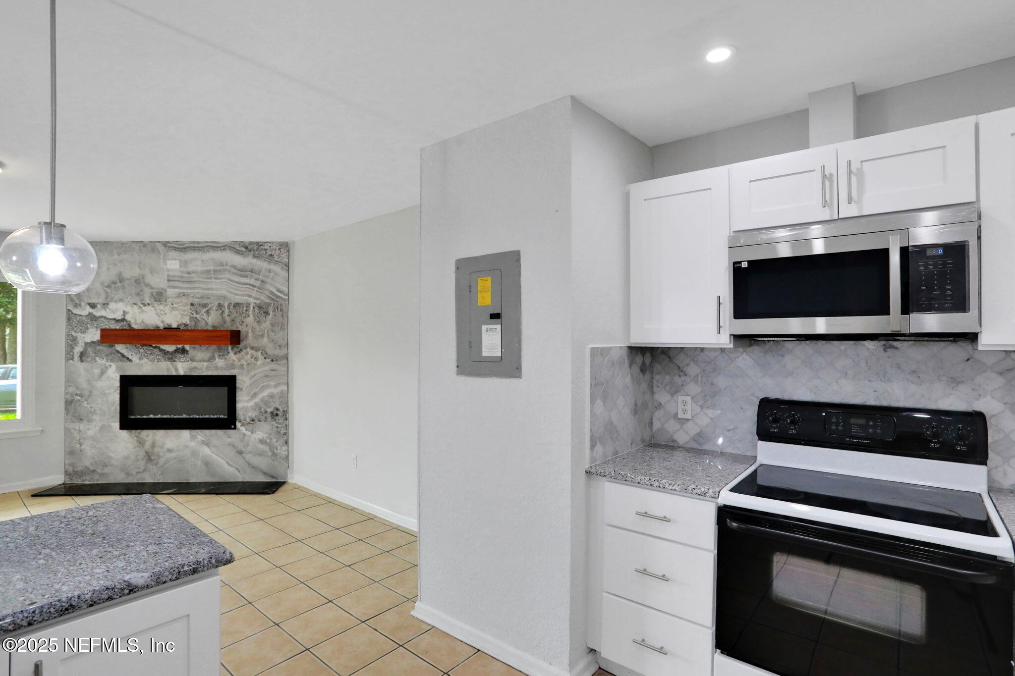 791 Assisi Lane, Unit 1704 Jacksonville, FL 32233 - Photo 6 of 16 a kitchen with stainless steel appliances granite countertop a stove and a microwave