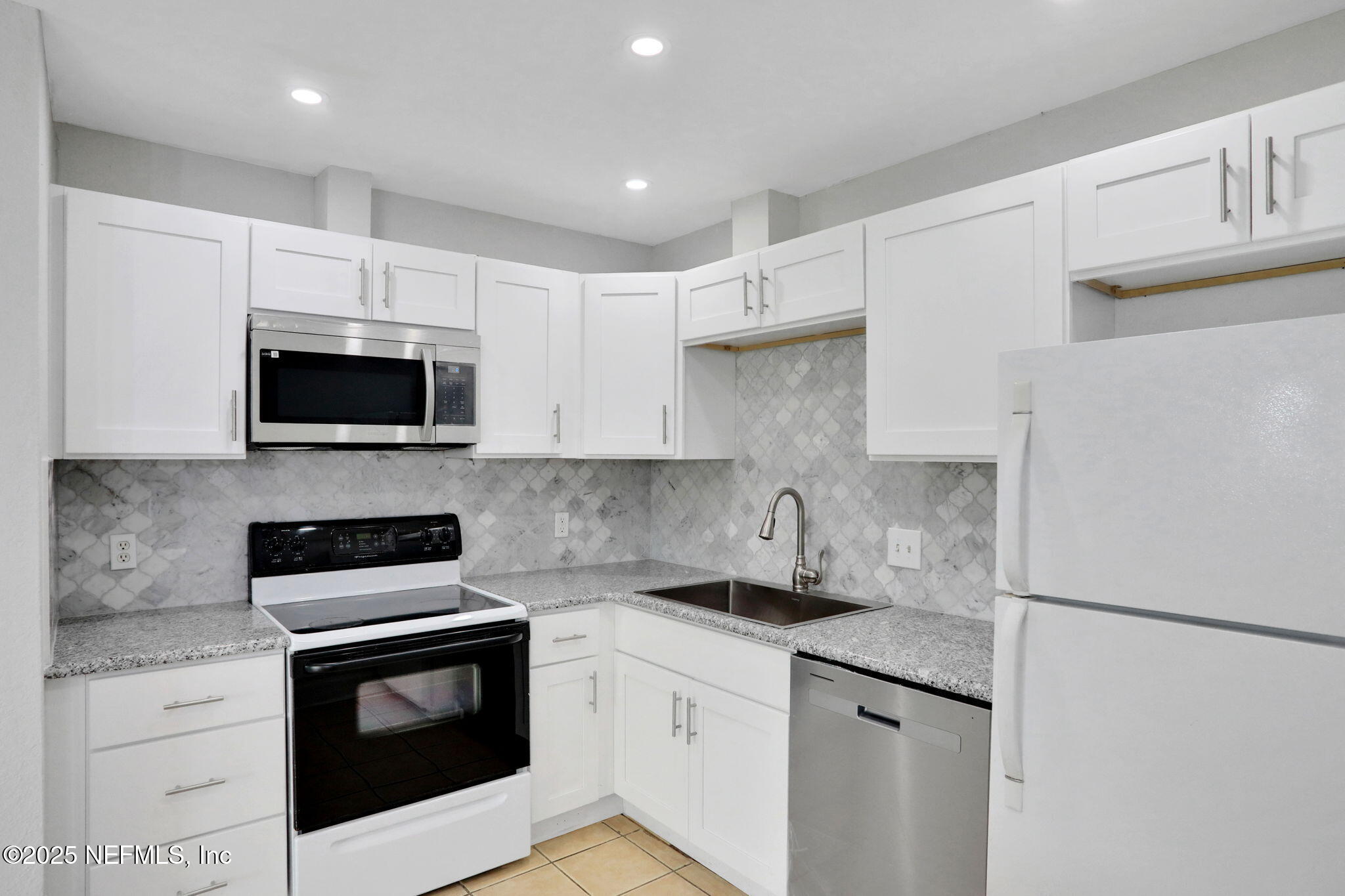 791 Assisi Lane, Unit 1704 Jacksonville, FL 32233 - Photo 7 of 16 a kitchen with a sink a stove and refrigerator